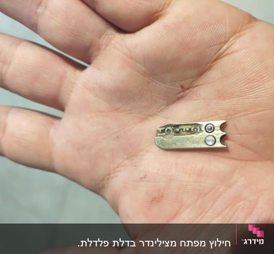 חלק מתכת קטן עם ברגים ביד אדם